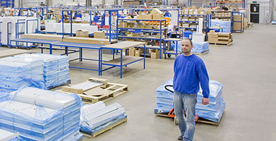 Man pulling a pallet through a warehouse.